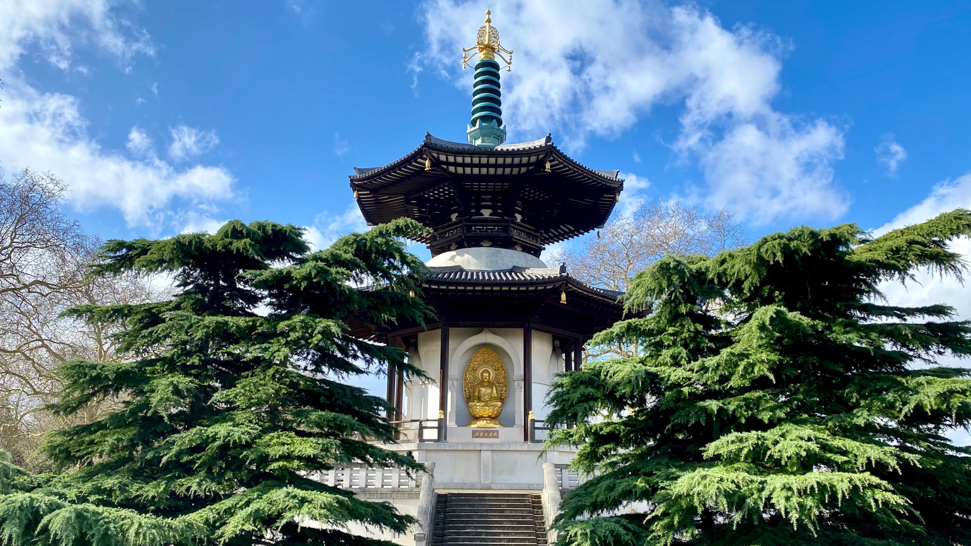 The pagoda at Battersea Park with trees on either side and clear blue skies.