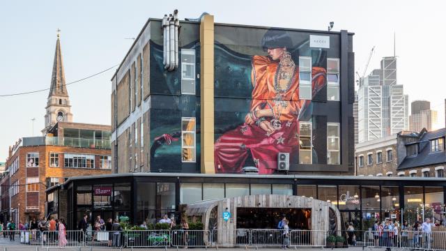 A large mural above a bar in Spitalfields. Image courtesy of visitlondon.com/Jon Reid. A large mural of a fashionable woman on the side of a building, above a bar, in Spitalfields.