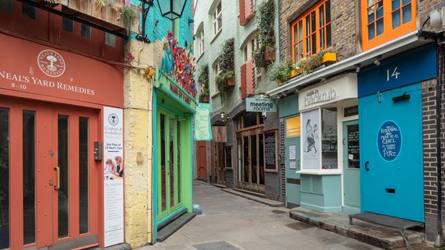 Shop indie boutiques in Seven Dials. Image courtesy of Visit London. Colourful alley of small shops at Neal's Yard in Covent Garden