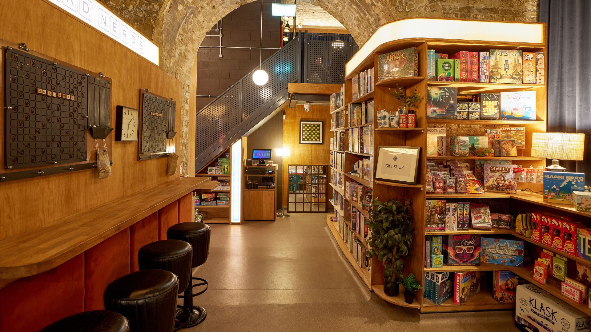 Head to Draughts Waterloo and dive into more than 1,000 games. Image courtesy of Draughts. Interior of Draughts Waterloo with stool seating at the front and board game shelfs on the right hand side.