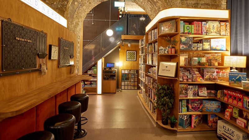 Head to Draughts Waterloo and dive into more than 1,000 games. Credit: Draughts. Image courtesy of Draughts. Interior of Draughts Waterloo with stool seating at the front and board game shelfs on the right hand side.