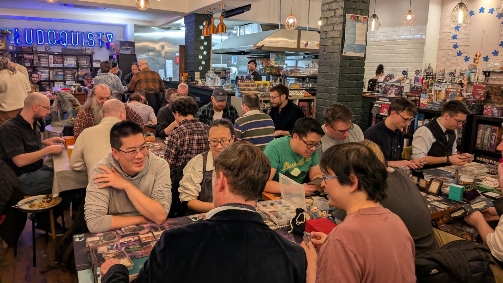 Catch up with friends over a classic board game or tabletop showdown at Ludoquist. Image courtesy of Ludoquist. Tables full of people playing board games at Ludoquist.