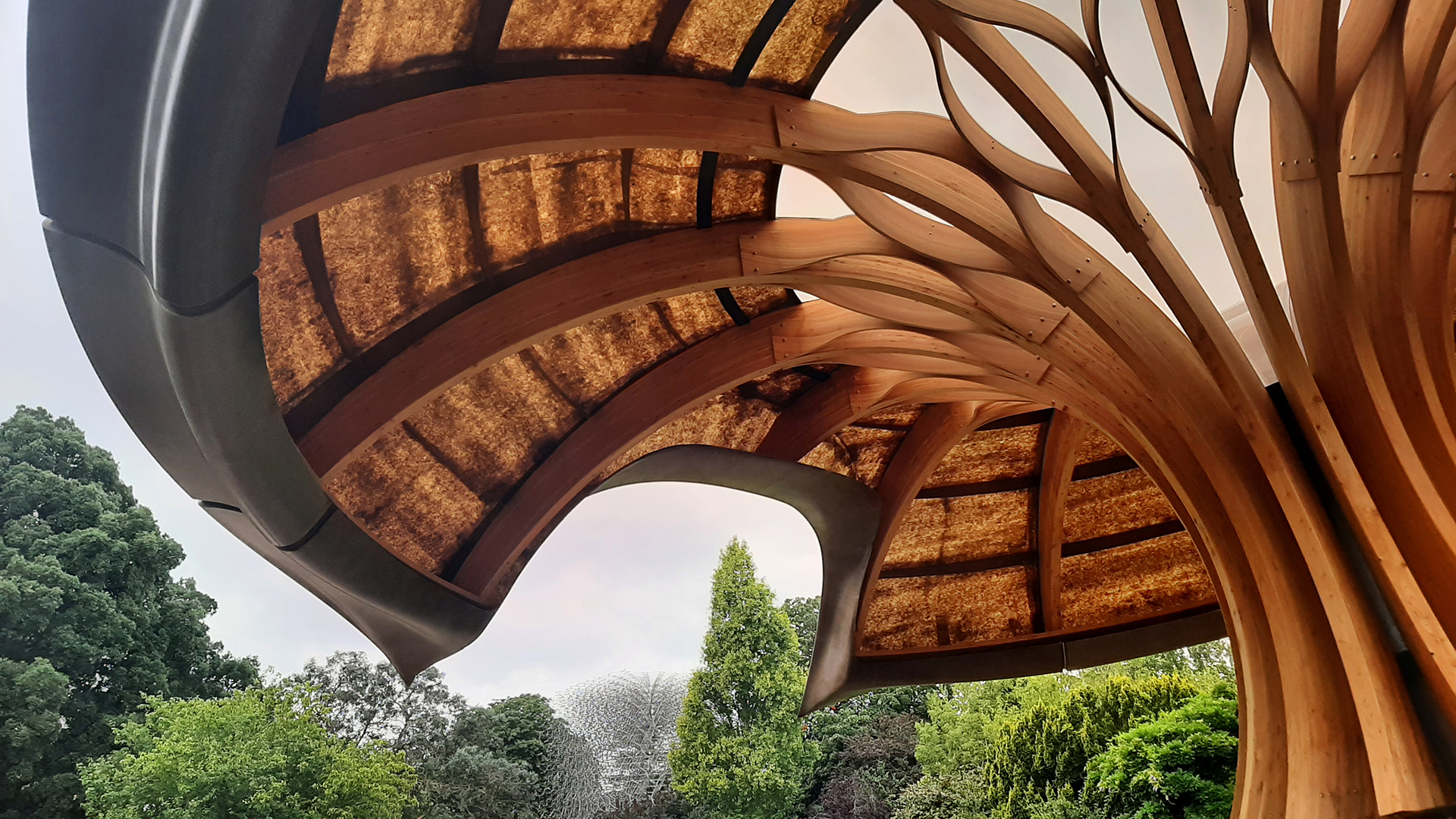 Explore the Pavilion at the Carbon Garden at Kew Gardens. © Visit London/Sigrun Tomicki A close up of the pavilion showing wood pannels and other natural materials with trees in the background.