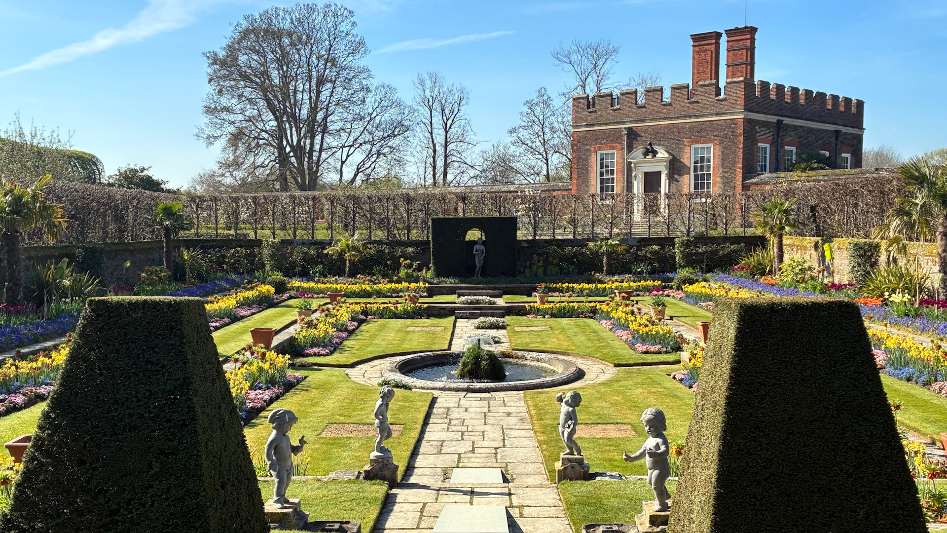 Spot tulips among other spring flowers in The Pond Garden Orange Quarter at Hampton Court Palace © visitlondon.com. Image courtesy of Jonny Payne. Topiary, grass, statues and spring flowers in The Pond Garden Orange Quarter at Hampton Court Palace.