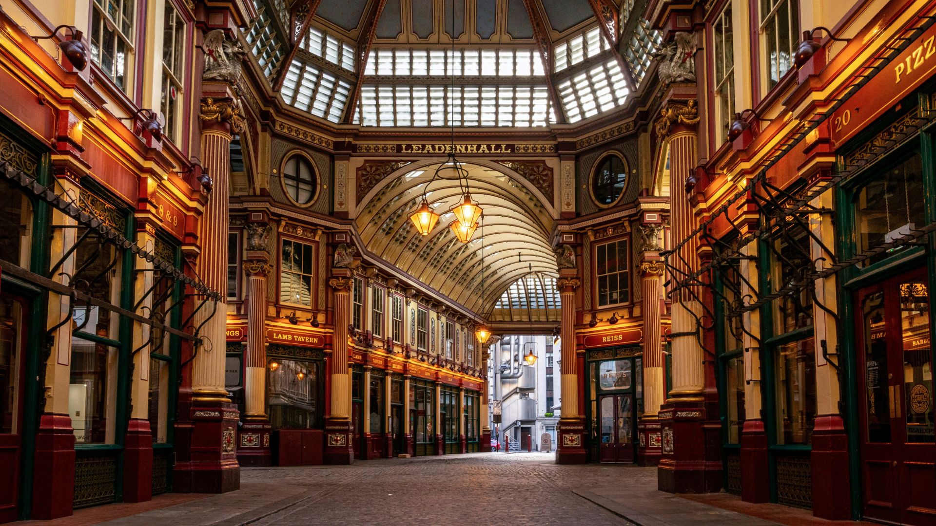 Discover the charm of Leadenhall Market in London. Image courtesy of Unsplash. Interior of Leadenhall Market in London with atmospheric orange lighting.