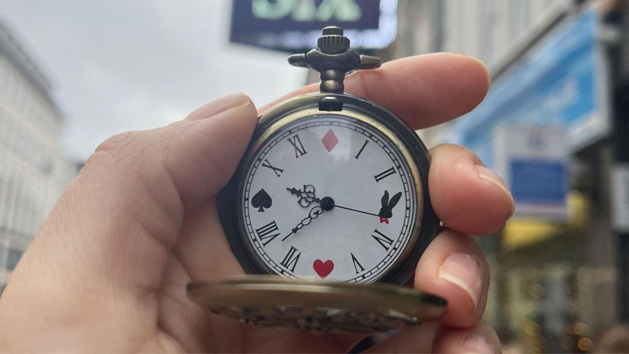 Roam the pretty streets of Covent Garden and track down the elusive Cheshire Cat in one of Hidden City’s captivating quests. © Carole Rocton. Image courtesy of Carole Rocton. Someone holds a pocket watch, its numbers replaced with whimsical rabbit-themed playing card symbols.