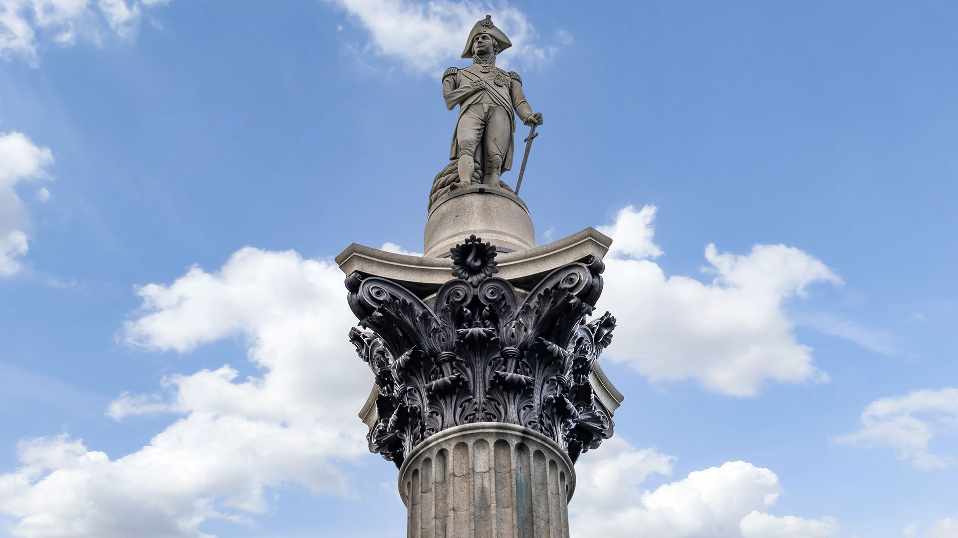 Vice-Admiral Lord Nelson's statue at the top of Nelson's Column in Trafalgar Square. Image courtesy of Shutterstock. A statue of Admiral Nelson at the top of Nelson's Column on a sunny day.