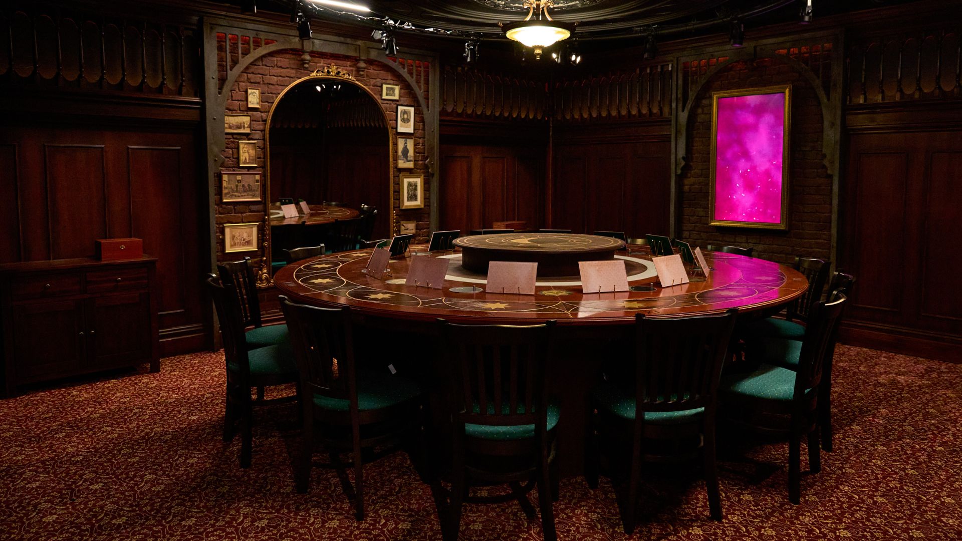 Plunge into the heart of the drama at The Traitors: Live Experience and take a seat at the Round Table. Image courtesy of Mance Communications. Round table with whiteboards lined next to each other and interactive screen in background.