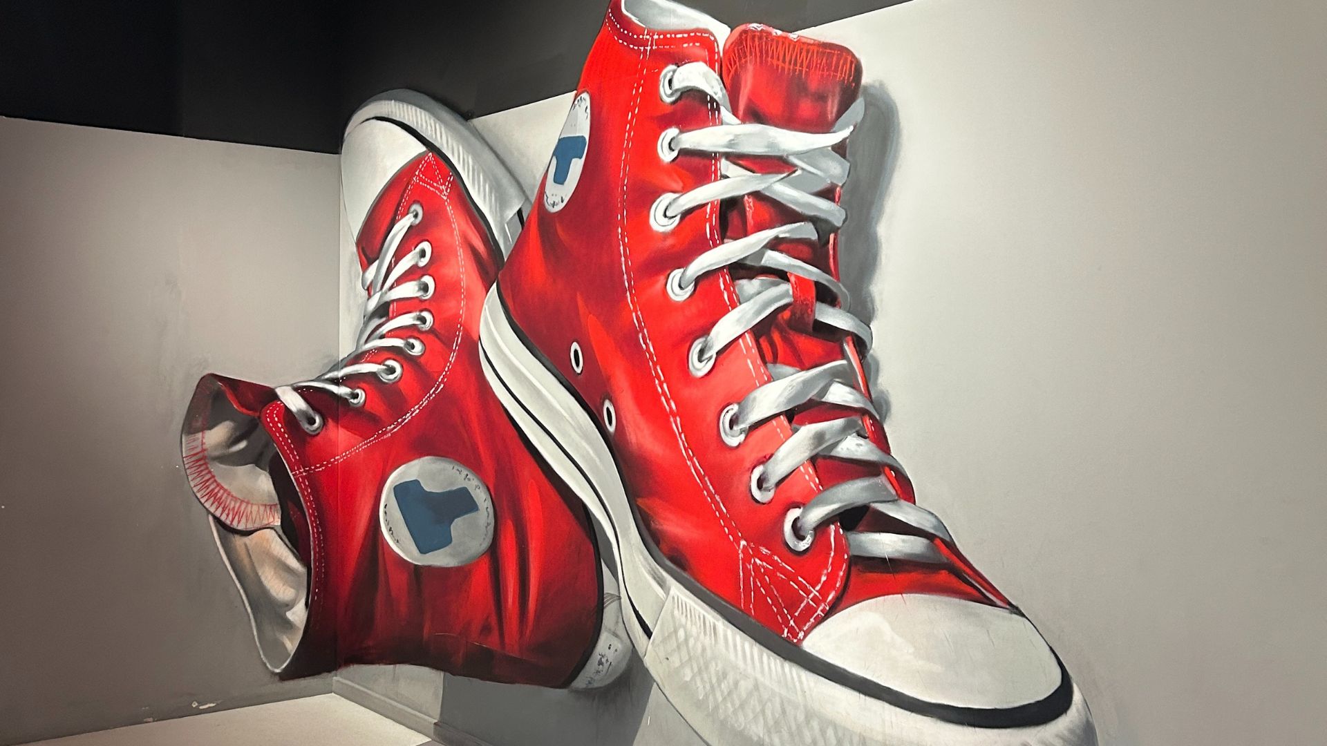 Put your senses to the test and explore the immersive gallery of illusions. © Visit London/Hannah Cornish a large pair of red Converse trainers painted on to a white wall, giving the illusion that they are floating in the air