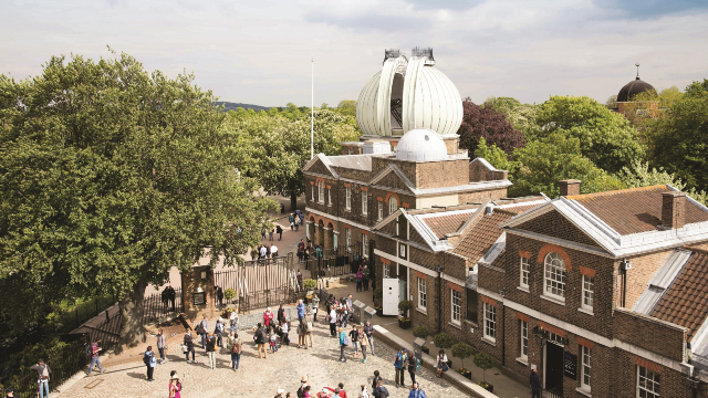 People walking around the Royal Observatory in Greenwich, on a sunny day.