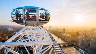 Visitors look out over the London skyline from a capsule of the London Eye at sunset