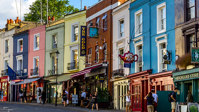 Colourful painted shop fronts on a street in Notting Hill, London.