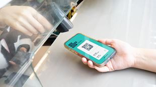 Person holding their phone with The London Pass on the screen for another person to scan.