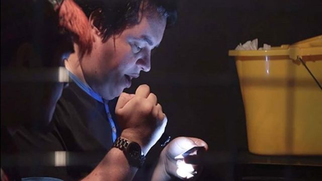 Can you bust your boss out of jail or solve the murder mystery at a movie premiere? Image courtesy of Red Letter Days. A man uses a torch to look at an escape room puzzle.