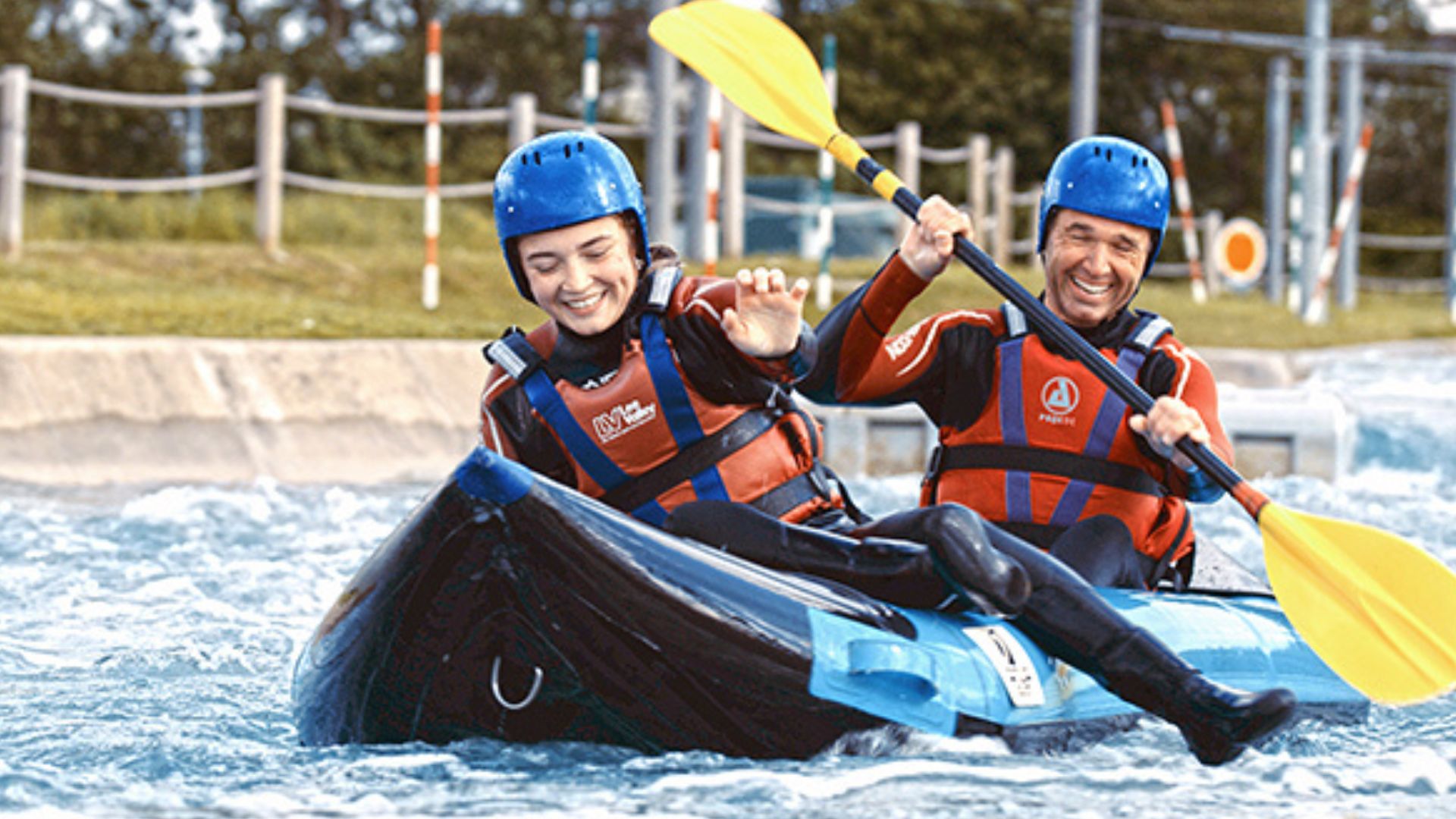 Hot Dog Kayaking at Lee Valley White Water Centre. Image courtesy of Red Letter Days. A woman and a man are kayaking along the river at Lee Valley Water Centre