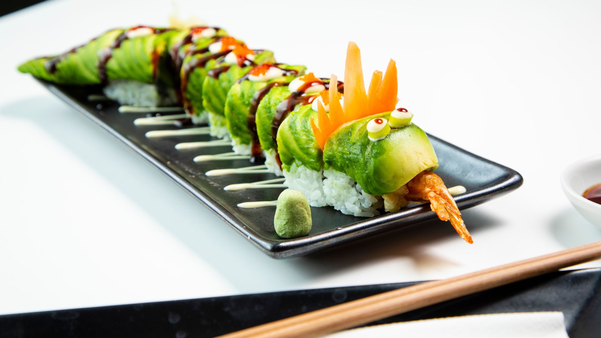 Join a sushi masterclass at Inamo. Image courtesy of Red Letter Days. rolled sushi displayed in the shape of a dragon, presented on a black plate