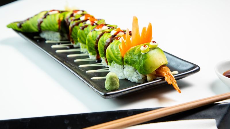 Join a sushi masterclass at Inamo. Credit: Red Letter Days. Image courtesy of Red Letter Days. rolled sushi displayed in the shape of a dragon, presented on a black plate