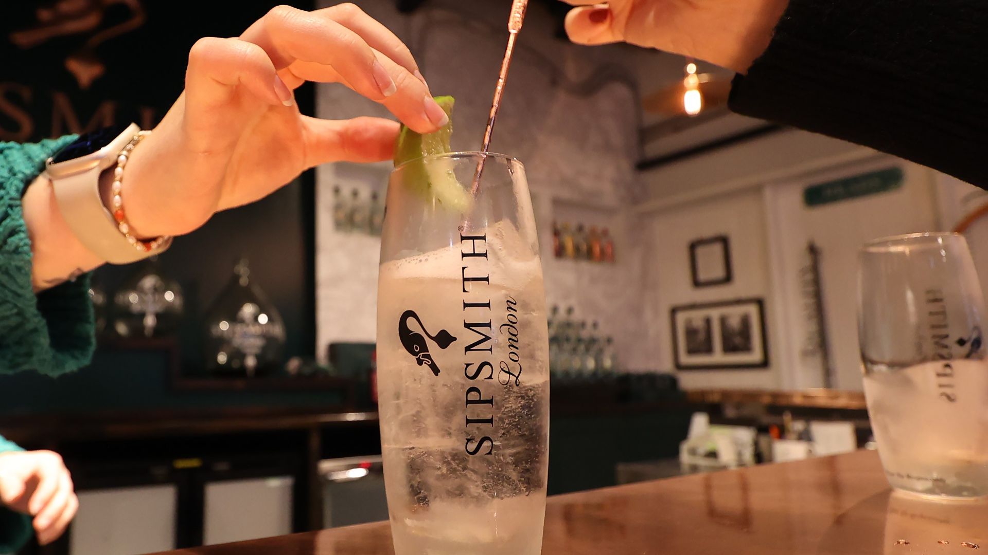 Join a gin masterclass at Sipsmith Gin. Image courtesy of Red Letter Days. a person stirring a cocktail in a Sipsmith gin glass