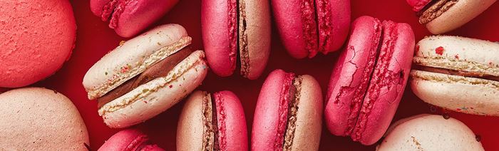 A selection of pink macarons with chocolate filling.