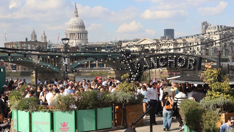 Take a seat in the riverside garden at Anchor Bankside, with views of the Thames. Credit: Paris Lynch. Image courtesy of Anchor Bankside. A photo of the riverside garden at Anchor Bankside with crowds of people sat down surrounded by foliage on a bright sunny day with a view of London Bridge and St Paul's Cathedral in the background