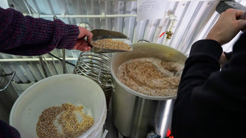 Book tickets to a beermaking experience at the London Beer Lab in south London. Credit: London Beer Lab. Image courtesy of London Beer Lab. A photo of someone scooping hops into a large pot with liquid during a beermaking experience at the London Beer Lab