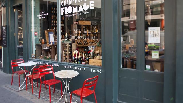 Red chair and white table and grey shop front. 