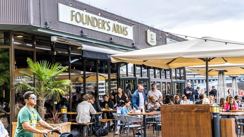 Stop for a cold drink at the Founder's Arms, just a stone's throw from Tate Modern. Credit: Shutterstock. Image courtesy of Shutterstock. A photo of the Founder's Arms pub on the Thames with benches filled with people and parasols overhead