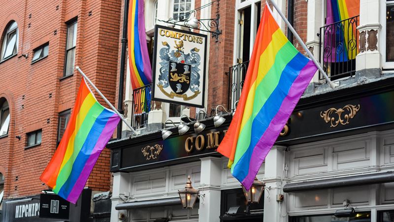 Enjoy pints and live sport at Soho's classic gay boozer, Comptons. Credit: Shutterstock. Image courtesy of Shutterstock. A photo of the exterior of Comptons pub in Soho with LGBTQ+ flags hanging from the outside