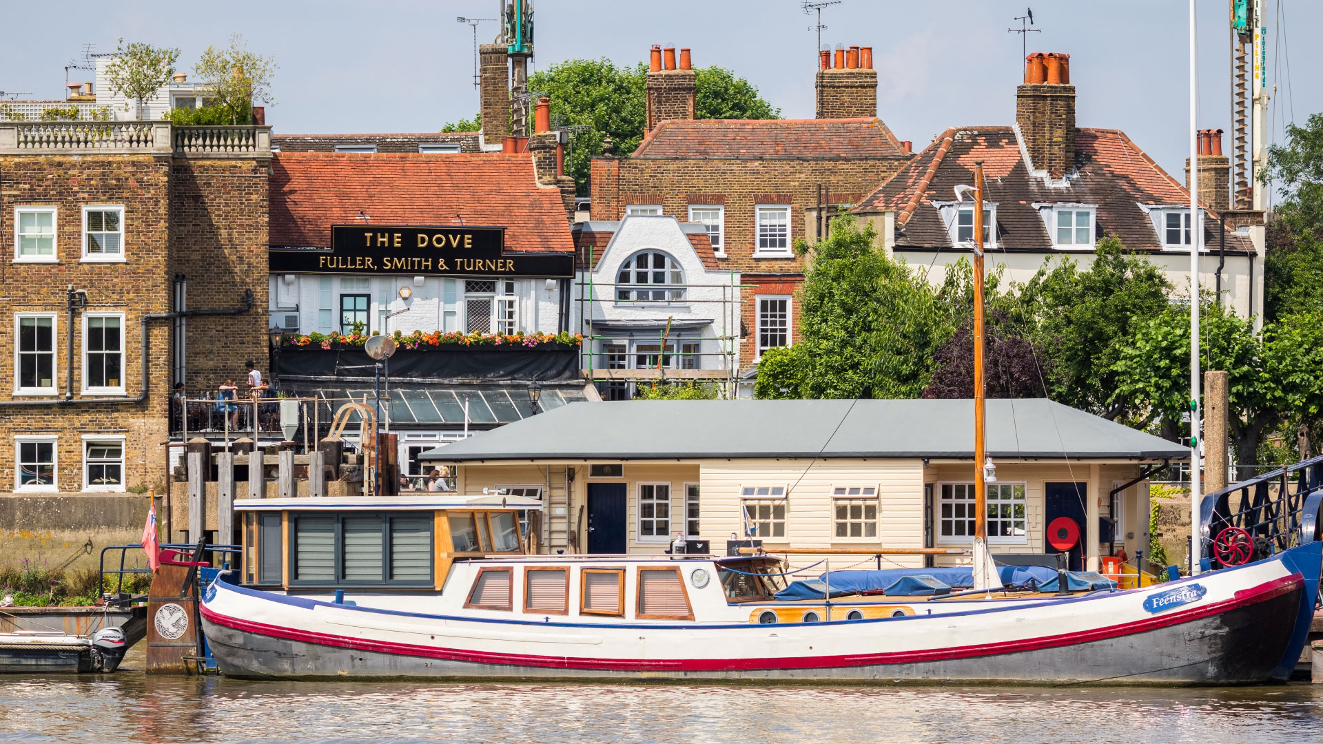 The Dove in Hammersmith boasts a garden and terrace with sweeping riverfront views. Credit: Shutterstock. Image courtesy of Shutterstock. A photo of the exterior of The Dove in Hammersmith with a boat on the Thames in the foreground