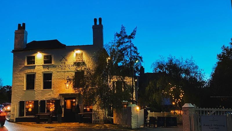Discover The Spaniards Inn in Hampstead, famous for its literary connections. Credit: The Spaniards Inn. Image courtesy of The Spaniards Inn. The facade of The Spaniards Inn pub in Hampstead lit up at night with clear dark blue skies.
