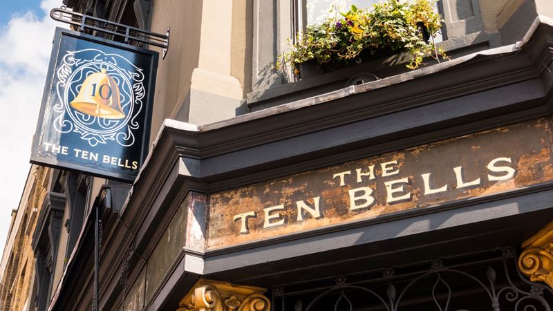 Step back in time at The Ten Bells in Shoreditch with a history dating back to the 17th century. Credit: Shutterstock. Image courtesy of Shutterstock. A photo of The Ten Bells signage outside the front of the pub with a blue placard hanging off the side of the building featuring a gold bell