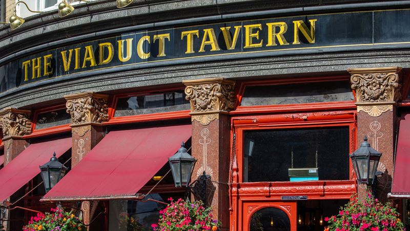 Make sure to visit the old prison cells in the basement of The Viaduct Tavern near St. Paul's. Credit: Shutterstock. Image courtesy of Shutterstock. A close up photo of the exterior of The Viaduct Tavern with gold lettering on a black background and red painted door