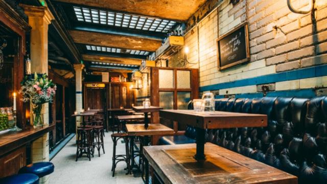 Indulge on expertly curated tipples and delicious charcuterie at WC Clapham. Image courtesy of Clapham Leisure. Photo credit: Tommy Reynolds. A wine bar with high tables and leisure benches.