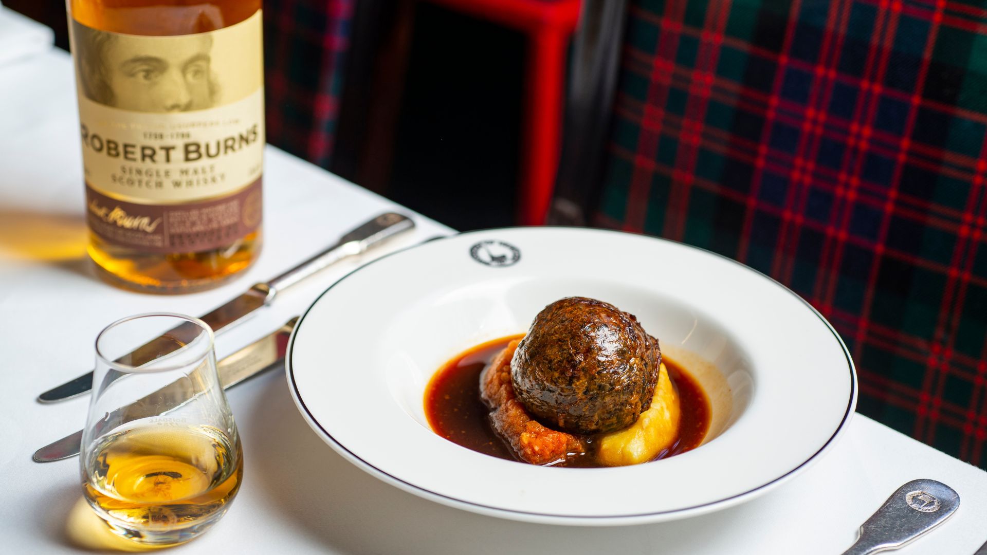 Tuck into delightful traditional Scottish dishes at Burns Night week at Boisdale. Image courtesy of Boisdale. A plate of haggis and a glass of whisky at boisdale burns night london.