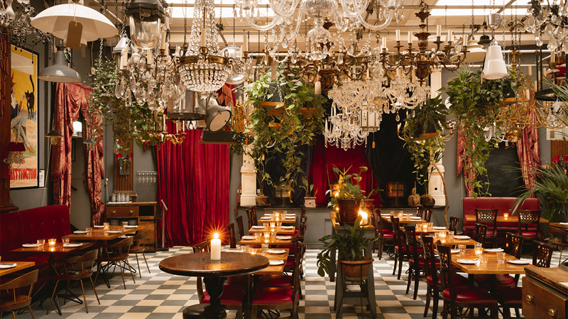 Enjoy a meal or drinks inside the fabulous Georgian mansion, Brunswick House. Credit: Alexander Baxter. Image courtesy of Brunswick House. Multiple hanging chandeliers, paintings, plants and red curtains adorn Brunswick House restaurant