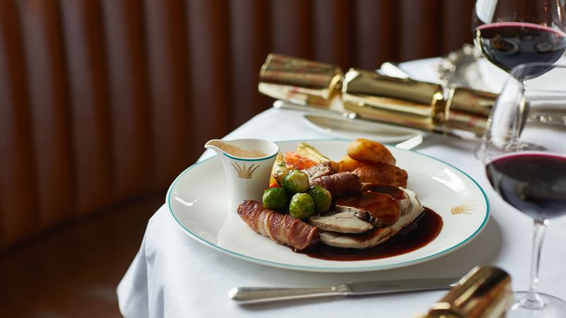 One of seven courses from the festive menu at The English Grill. Credit: The Rubens at the Palace. Image courtesy of The Rubens at the Palace. A traditional Christmas Day dinner with two glasses of red wine and gold Christmas crackers.