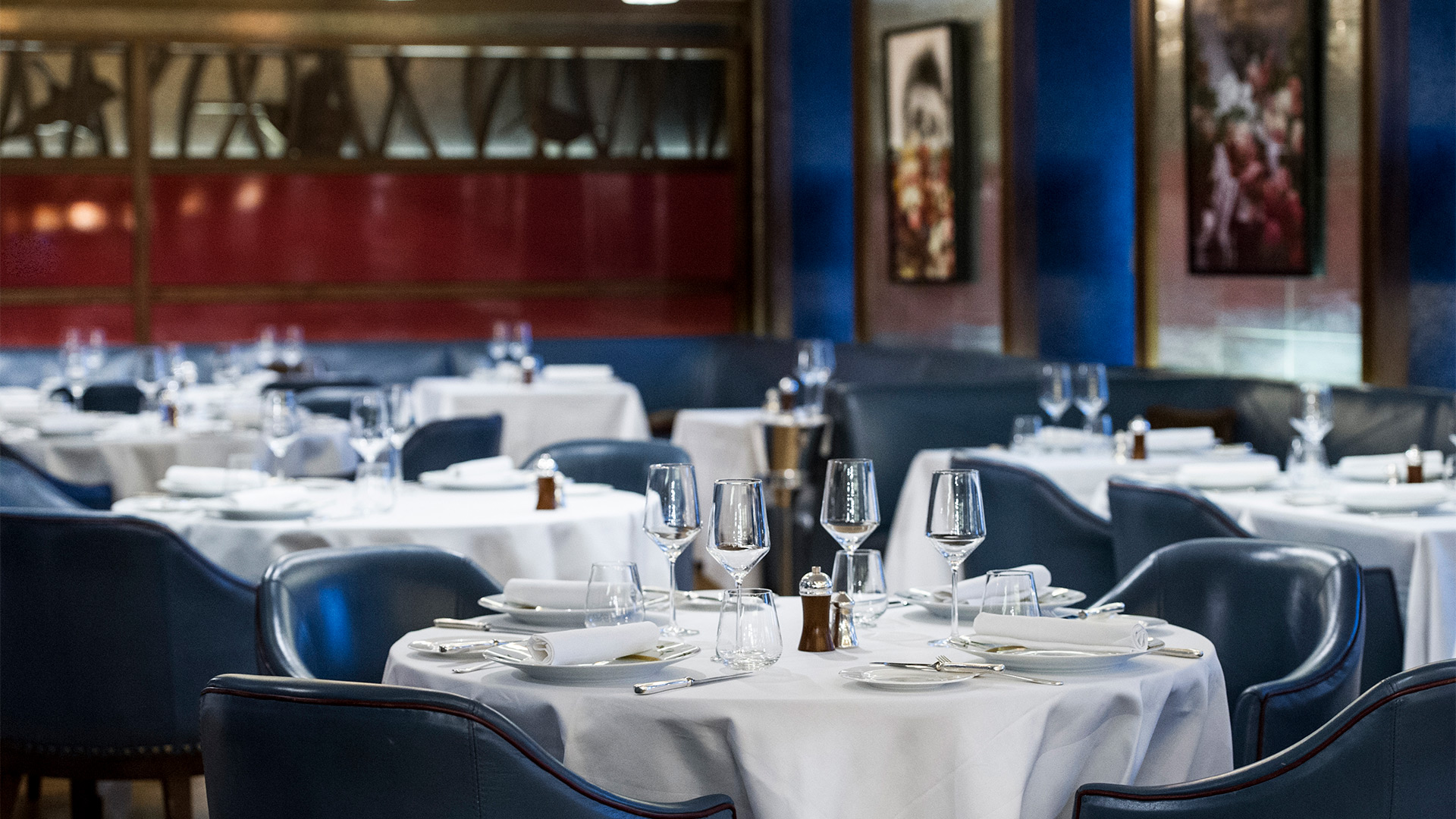 Explore a menu inspired by British and Irish cuisine during a sitting at Corrigan's Mayfair. Credit: Corrigan's Mayfair. Image courtesy of Corrigan Collection. The empty dining room at Corrigan's Mayfair, with blue velvet chairs and white tablecloths.