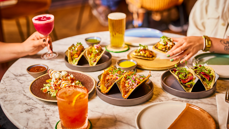 Let kids build their own tacos or order from the mouthwatering a la carte menu at Wahaca restaurants across London. Credit: Wahaca. Image courtesy of Wahaca. A white marble table with plates of colourful Mexican food including tacos and enchiladas, cocktails and beer