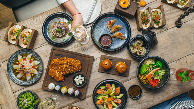 Plates of Korean food at Jinjuu. Photo: @Lateef Photography. Image courtesy of Jinjuu Multiple plates of food, on a table, take from above.
