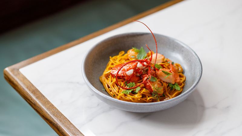 Visit the Michelin-starred Luca Restaurant for a variety of traditional trattoria dishes with a modern twist. Credit: Luca Restaurant. Image courtesy of Luca Restaurant. A colourful plate of pasta topped with grilled seafood is served at Michelin starred Italian restaurant Luca.