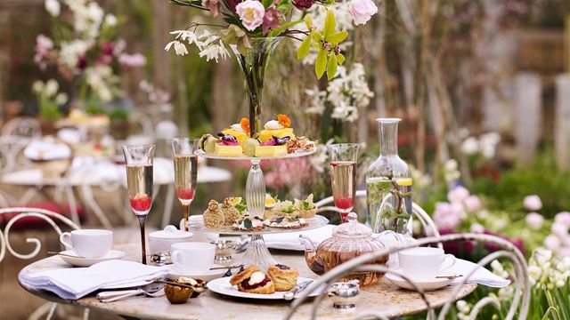 An outdoor table at The Teahouse with an afternoon tea spread.