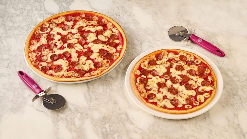 Choose from any toppings on Pizza Express' menu and swap to a gluten-free base. Credit: Pizza Express. Image courtesy of Pizza Express. A photo of two gluten-free pizzas with cheese, tomato and pepperoni at Pizza Express with pizza cutters next to each