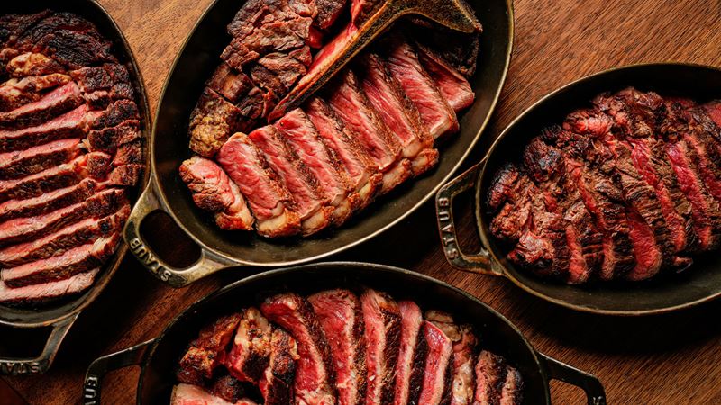 A bird's-eye photo of four big dishes of sharing steak at Hawksmoor, each perfectly cooked with pink middles