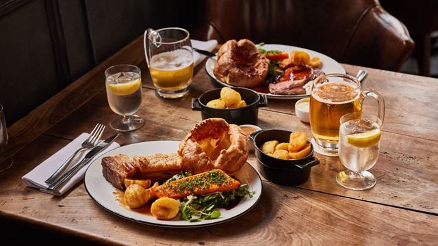 Roast dinner plates and drinks on a table at the chelsea pig.