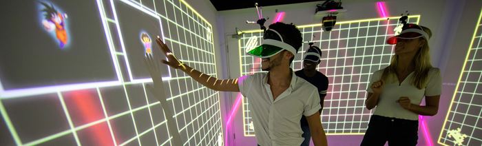 A male and female group finding experiences to try in London, as they play an immersive game in a multicoloured LightBox.