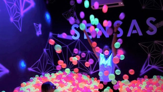 The colourful ball pit at immersive multisensory experience SENSAS © SENSAS. Image courtesy of SENSAS. Two people playing in a ball pit full of multi-coloured balls at SENSAS