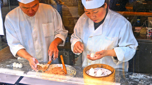 Making dumplings at Dumplings' Legend in London Chinatown. Image courtesy of Shutterstock. Two chefs make dumplings at Dumplings' Legend in London Chinatown.