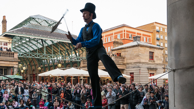 Catch a free street performance in the Piazza. Image courtesy of Shutterstock. A street performer entertains the crowds in Covent Garden's Piazza, London.