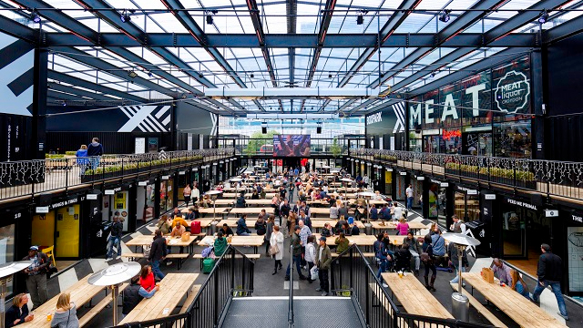 inside view of Boxpark Croydon showing benches and storefronts.
