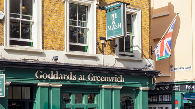 A Victorian-style pub with a green painted front and a Union Jack flag.